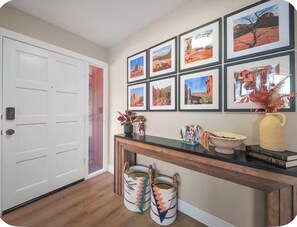 A hallway with a wooden console table, framed pictures, and two woven baskets. - Oak Creek Escape-Golf&Red Rock Adventure (Sedona)