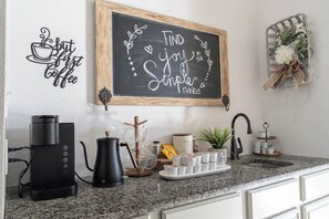 A kitchen with a coffee maker, a kettle, and a coffee station. - Spacious Arlington 5BR Sleeps 12 Near AT&T Stadium & Stovall Park (Arlington)