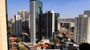 A high-rise building with a modern architectural design, surrounded by other high-rise buildings and construction cranes, indicating ongoing development. - Studio Nex One Faria Lima - A 3 min do Metrô (São Paulo)