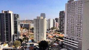 A high-rise building with multiple floors, surrounded by other high-rise buildings. - Studio Nex One Faria Lima - A 3 min do Metrô (São Paulo)