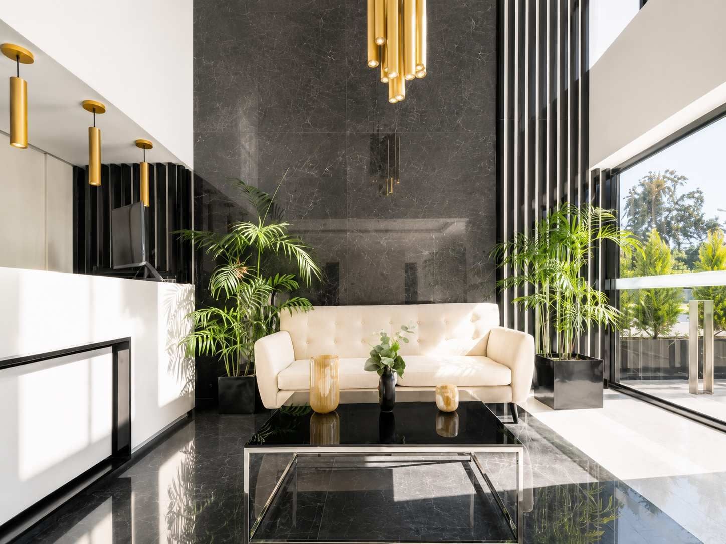 Ein modernes Interieur mit einer Couch, einem Couchtisch und Topfpflanzen.