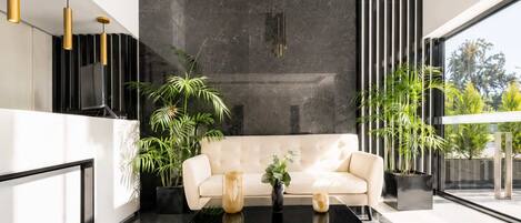 Ein modernes Interieur mit einer Couch, einem Couchtisch und Topfpflanzen.