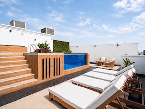 A rooftop terrace with a swimming pool, lounge chairs, and a wooden staircase. - Suite de Diseño con Piscina y Rooftop  (San Isidro)