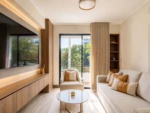 A modern living room with a sofa, a coffee table, and a TV. - Suite de Diseño con Piscina y Rooftop  (San Isidro)