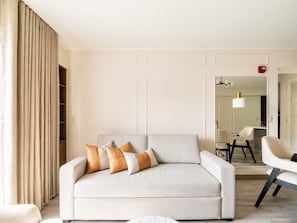 A modern living room with a sofa, a chair, and a lamp. - Suite de Diseño con Piscina y Rooftop  (San Isidro)