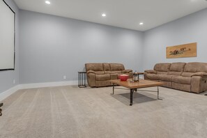 A room with beige carpet, two brown sofas, a wooden coffee table, and a small side table. - Magical Family Escape: Treehouse, Games, Memories (Spring Hill)
