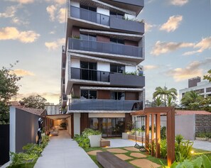 A multi-story residential building with balconies, a covered walkway, and a garden area. - Way Bossa #G2 - Flat in Bessa by Carpediem (João Pessoa)