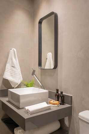 A modern bathroom with a rectangular sink, a mirror, a towel, and toiletries. - Way Bossa #G2 - Flat in Bessa by Carpediem (João Pessoa)