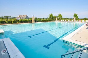Ein klares Schwimmbecken mit Rettungsschwimmerstuhl und Poolleiter.