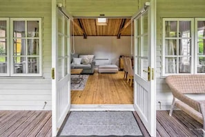 Step from the veranda into the cabin's bright lounge - Garden Studio in Victoria Park - Free Parking (Manchester)