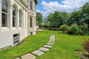 A pathway leading to a building with a white facade and large windows. - Garden Studio in Victoria Park - Free Parking (Manchester)