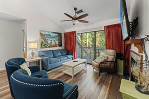 A living room with a blue sofa, a wooden coffee table, and a painting on the wall. - W Hyde Pk 11E in Kingston 2nd floor, Pool, Beach (Myrtle Beach)