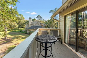 A wooden deck with a round table and chairs, overlooking a backyard with a house and trees. - W Hyde Pk 11E in Kingston 2nd floor, Pool, Beach (Myrtle Beach)