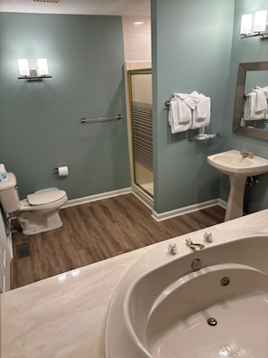 Ein Badezimmer mit Badewanne, Toilette, Waschbecken und einer Duschkabine aus Glas.