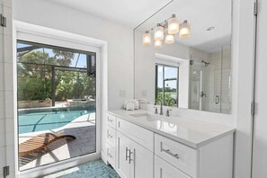 A modern bathroom with a large window, a built-in sink, and a shower area. - Point of View - Sanibel Island House with Private Pool, Lake Views & Beach Access! (Sanibel)