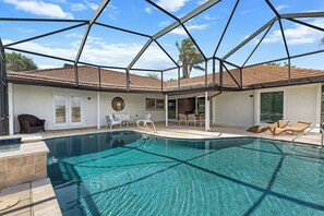 A swimming pool with a geometric glass enclosure, lounge chairs, and a patio area. - Point of View - Sanibel Island House with Private Pool, Lake Views & Beach Access! (Sanibel)