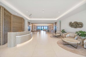 A spacious lobby with a reception desk, seating area, and a large window offering a view. - Apex Modern Condos-408 W Bay St Nassau (Nassau, The Bahamas)