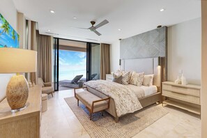 A modern bedroom with a large bed, a bedside table, a nightstand, a ceiling fan, and a view of the outdoors. - Apex Modern Condos-408 W Bay St Nassau (Nassau, The Bahamas)