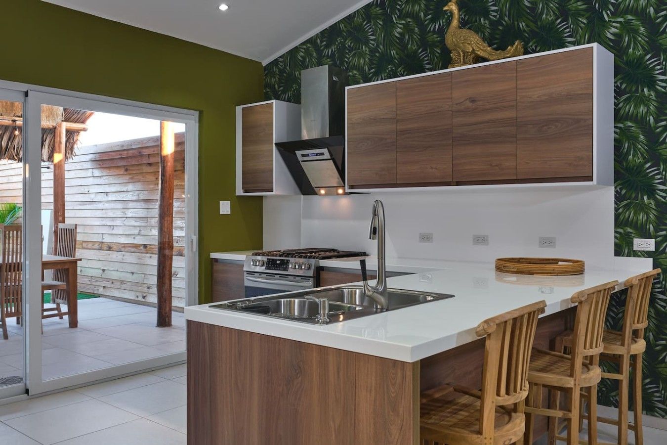 Une cuisine moderne dotée d’un îlot central, d’un évier en acier inoxydable et de meubles de rangement en bois.