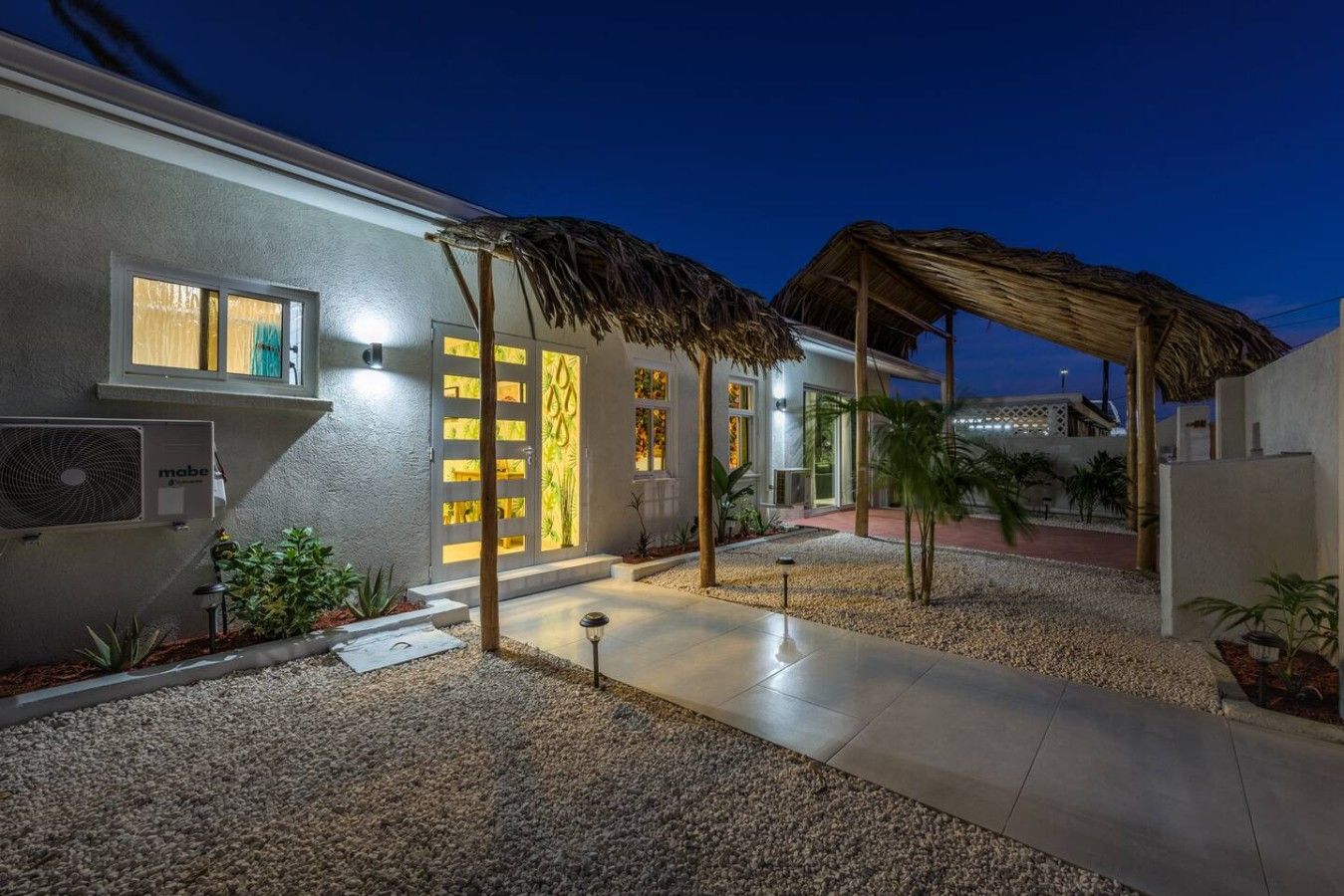 A modern building with a covered outdoor area, a water feature, and a well-maintained garden.
