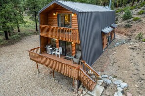 A cabin with a balcony, a grill, and outdoor seating. - Ponderosa Pines Cabin Retreat (Duck Creek Village)