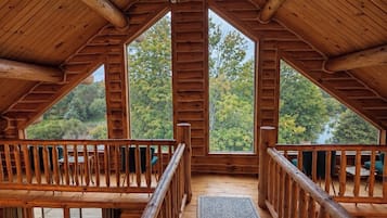 Eine Holzhütte mit hohen Decken und großen Fenstern.