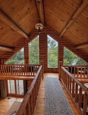 Una cabaña de madera con techo alto y ventanas amplias.