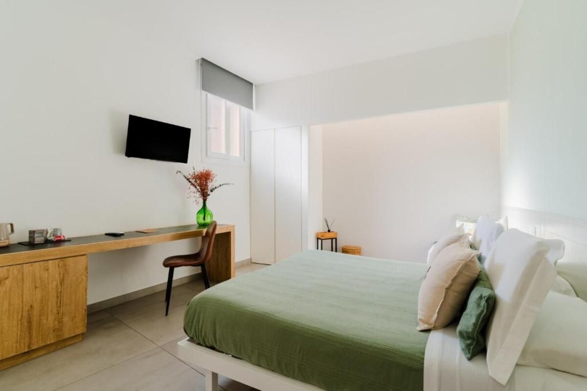 A modern bedroom with a bed, a desk, and a chair.