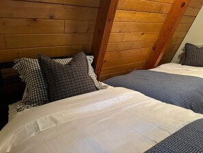 A bedroom with two beds, wooden headboard, and checkered pillows. - The Highpoint A-Frame | Walkable | BBQ | Max 4 (Big Bear Lake)