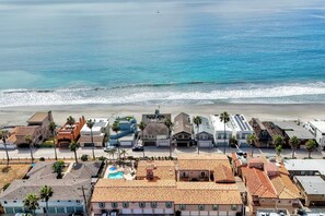 A coastal residential area with houses, a swimming pool, and a beach. - Mermaid Cove With Beach Days & Hot Tub Nights! AC, Ocean, Pool/HotTub (Oceanside)