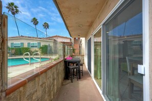 Un balcone con piscina, mobili da esterno e vista sulle case limitrofe.