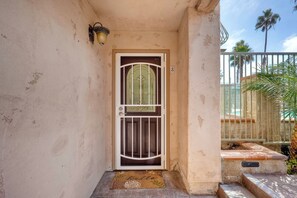 A house entrance with a double door, a doormat, and a small balcony with a railing. - Mermaid Cove With Beach Days & Hot Tub Nights! AC, Ocean, Pool/HotTub (Oceanside)