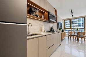 Eine moderne Küche mit integriertem Mikrowellenherd, Kaffeemaschine und Mixer.