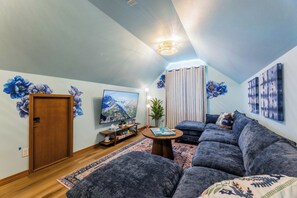 A living room with a sofa set, a television, and decorative wall art. - Ridgeview Lodge at Beaver Lake (Garfield)