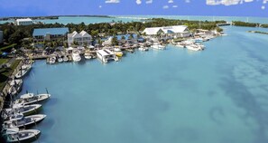 Ein Hafen mit mehreren vertäuten Booten, ein Gebäude mit blauem Dach und freier Sicht auf das umgebende Wasser und Land.
