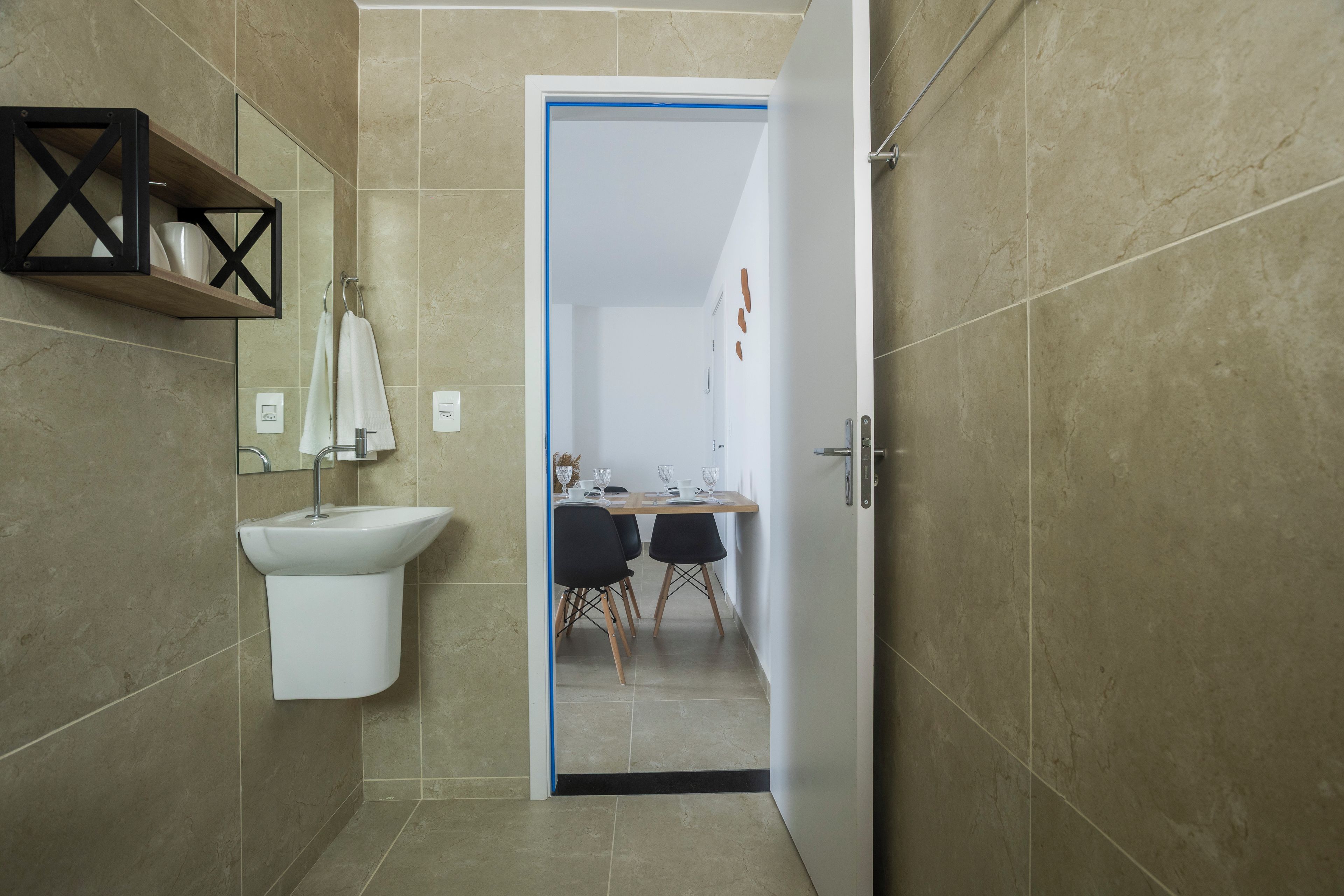 Un baño moderno con un lavamanos blanco, un espejo y una zona de ducha.