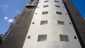 Un edificio alto con un reloj en la fachada, múltiples ventanas y un letrero que dice 'COMFORT'.
