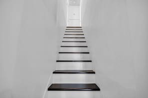 A straight staircase with alternating white and dark steps leading to a door at the top. - Hot Tub - Walk Downtown SH - 4BR (Safety Harbor)