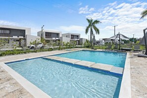 A rectangular swimming pool with clear blue water, surrounded by a paved deck. - 3BR Villa w/ Patio, Pool Near Downtown & Beaches (Punta Cana)