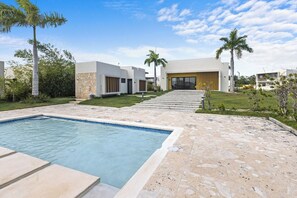 A modern residential property with a swimming pool, a covered patio, and a well-maintained lawn. - 3BR Villa w/ Patio, Pool Near Downtown & Beaches (Punta Cana)