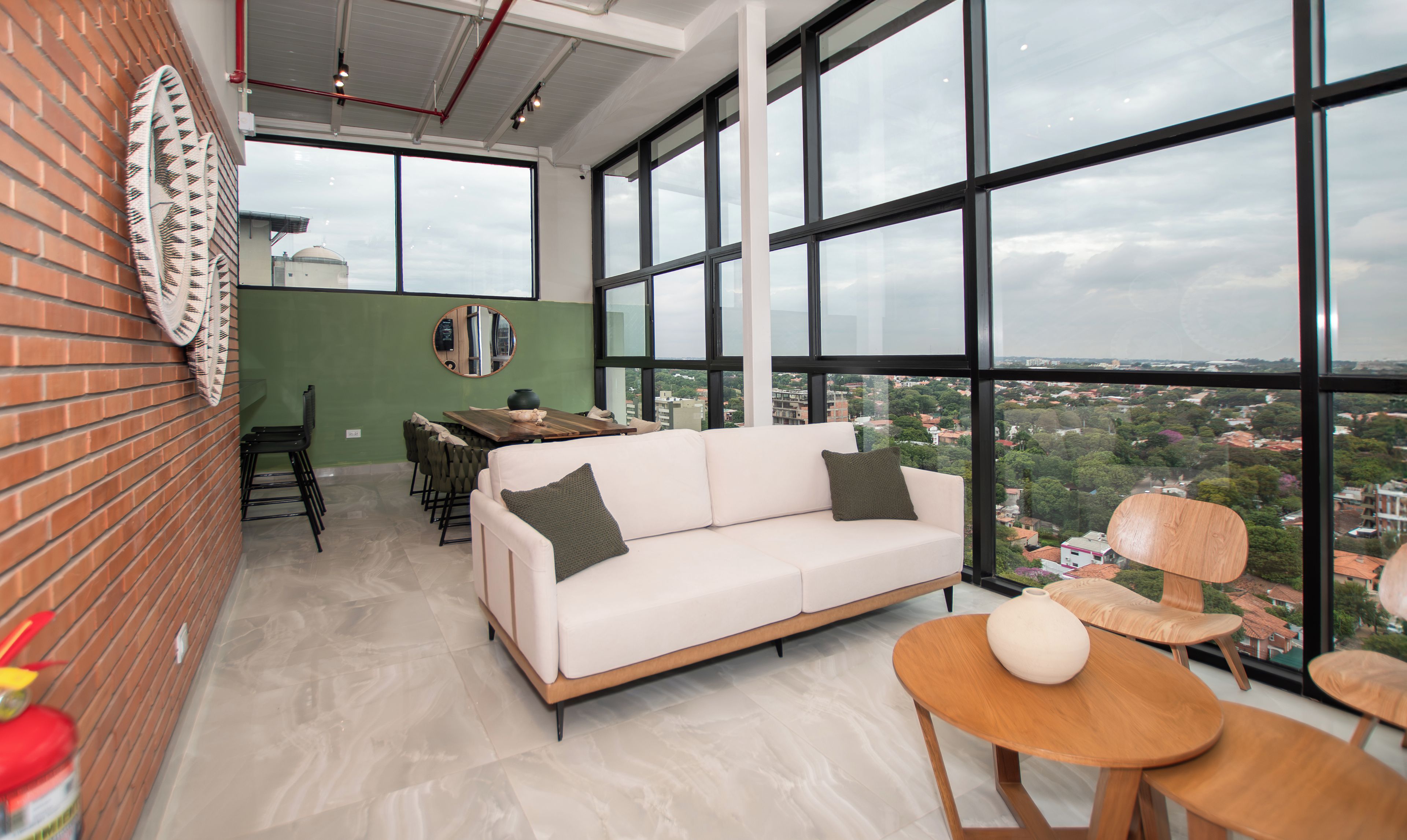 Een modern interieur met een witte bank, een eettafel en grote ramen met uitzicht op de stad.