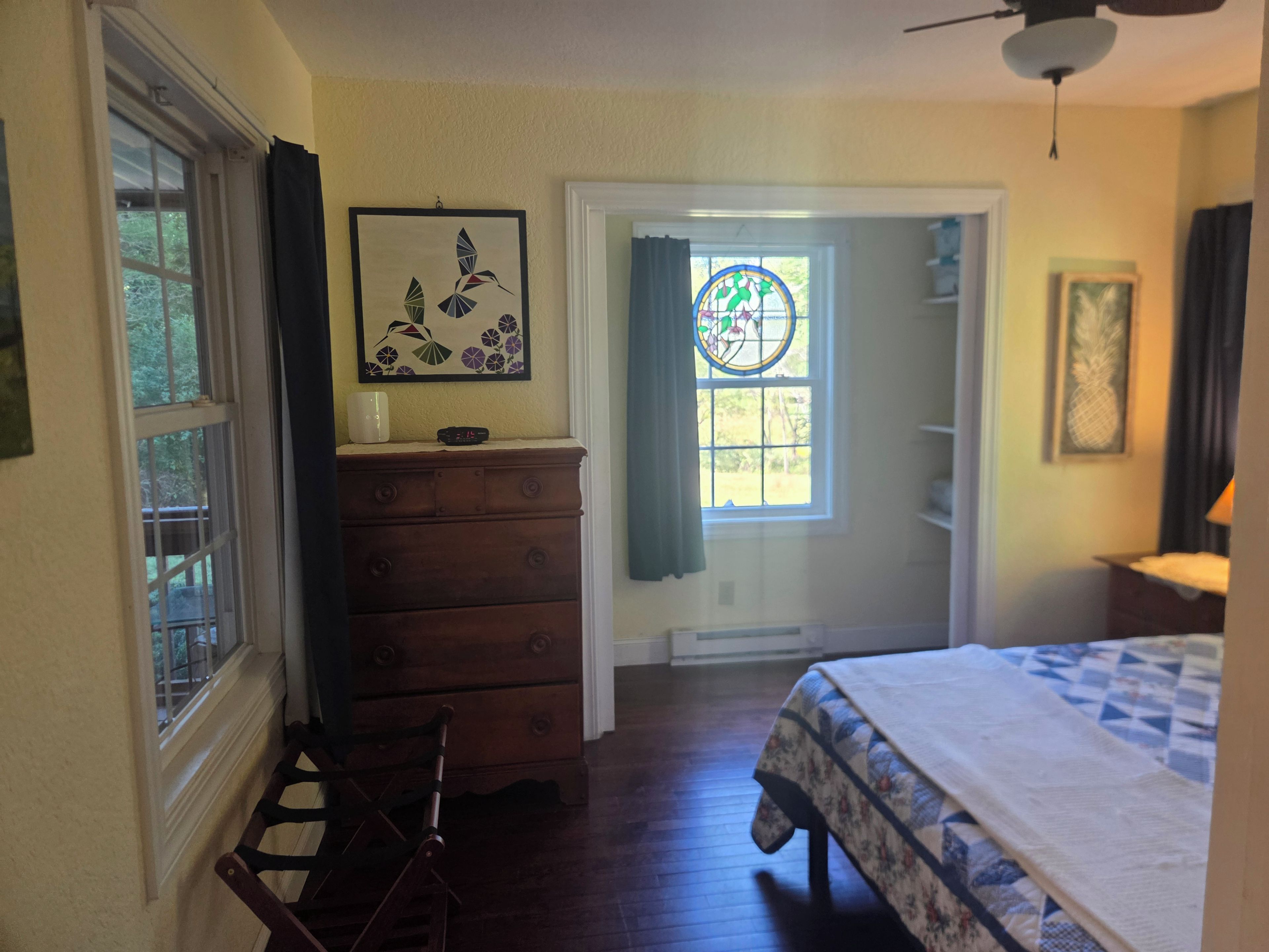 A bedroom with a bed, dresser, chair, and a door leading to a balcony.