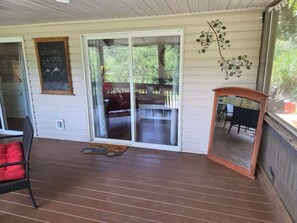 A covered porch with a sliding glass door leading to an outdoor seating area.
