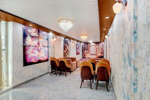 A room with a marble floor, a chandelier, and wall art. - Classic Hotel Dream Palace (Danapur)