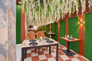 A restaurant interior with a checkered floor, wooden tables, and chairs.