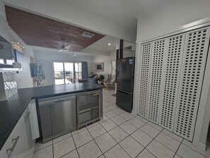 A modern kitchen with a dishwasher, refrigerator, and a glass-enclosed oven. - Villa 36 - Tangalooma - Moreton Island (moreton island)