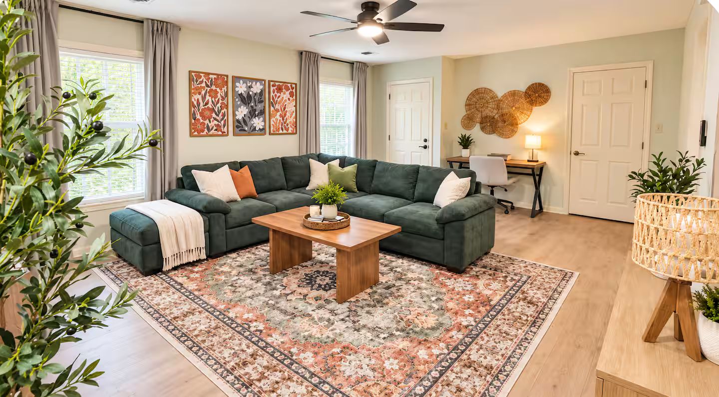 A living room with a sectional sofa, a wooden coffee table, and a patterned rug.