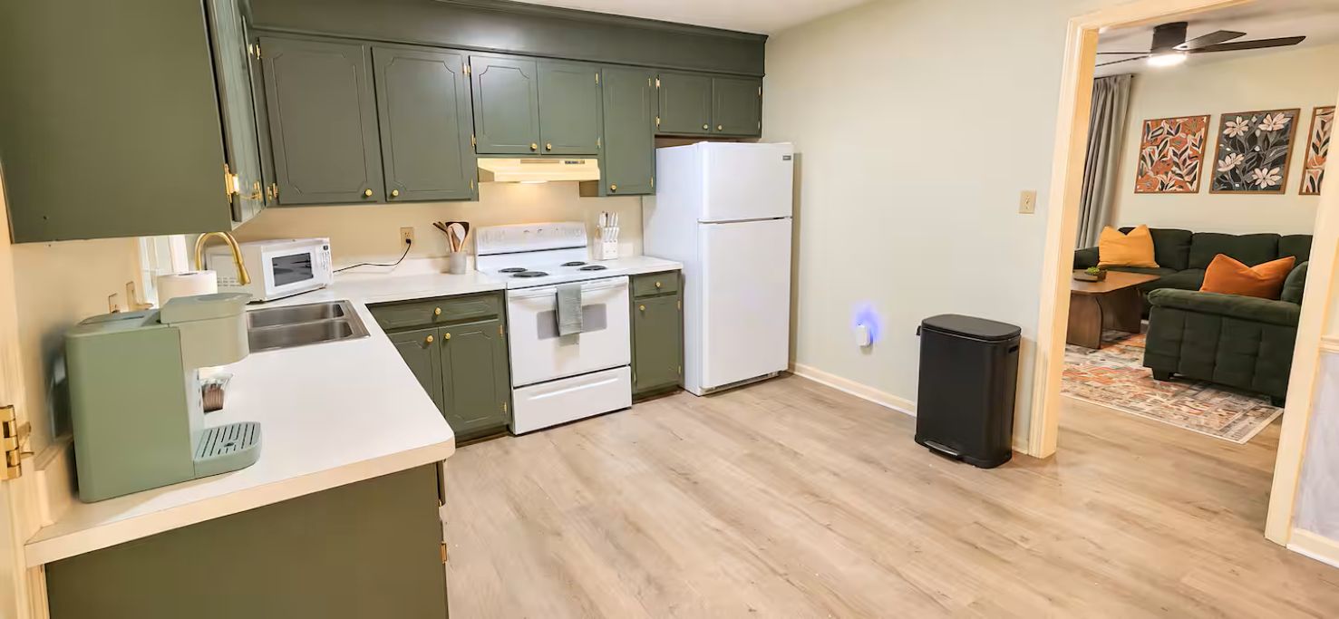A compact kitchen with a microwave, stove, and refrigerator.