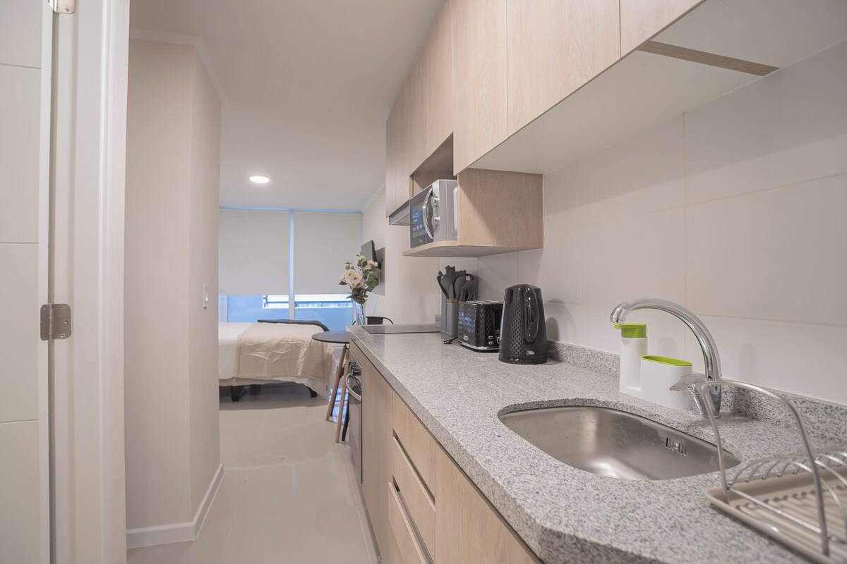 A modern kitchen with a granite countertop, stainless steel sink, and a built-in oven.
