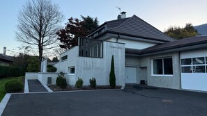 A modern two-story house with a grey facade, a sloped roof, and a garage. - Family Home on Lake Annecy (Saint-Jorioz)